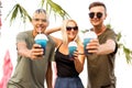 Three friends cheerful company rest on a tropical beach and drink cocktails, very, magazine concept Royalty Free Stock Photo