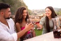 Three friends clinking glasses outdoor at sunset - Mixed race person group toasting with red wine glasses in countryside for the Royalty Free Stock Photo