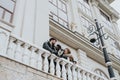 Three friends enjoying time together on a historic balcony overlooking the city. Royalty Free Stock Photo