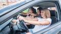 Three friends go on a trip. Caucasian women drive in a car and point fingers in surprise. Royalty Free Stock Photo