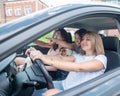 Three friends go on a trip. Caucasian women drive in a car and point fingers in surprise. Royalty Free Stock Photo