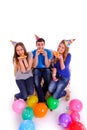 Three friends with hats and balloons eating pizza Royalty Free Stock Photo