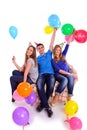 Three friends in hats with balloons sitting on the couch Royalty Free Stock Photo