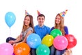 Three friends in hats with balloons sitting on the Royalty Free Stock Photo
