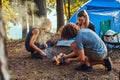 Three friends hiking in the forest and try to light a fire at camp. Royalty Free Stock Photo