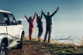 Three friends joined hands and raised their hands up, enjoying the view of Outdoor.Vacations Journey Concept