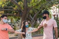 Three friends outdoors wearing face masks and respecting social distancing during a pandemic