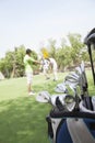 Three friends playing golf on the golf course, focus on the caddy Royalty Free Stock Photo