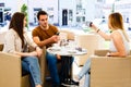 Three friends sitting at cafe while one of them is bussy by taking selfie Royalty Free Stock Photo