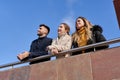 Three friends talking cordially. Leaning on a railing. Friendship concept Royalty Free Stock Photo