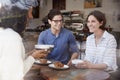 Three friends talking and drinking coffee at a coffee shop Royalty Free Stock Photo