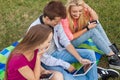 Three friends watching funny movies on tablet pc in park.