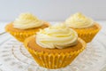 Three frosted cupcakes on a glass serving plate Royalty Free Stock Photo
