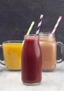 Three Fruit Smoothies in Various Cups with Paper Straws Royalty Free Stock Photo