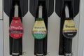 Three fuelling nozzles with gasoline and diesel of shell company attached to fuel pump dispenser.