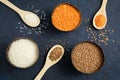 Three full bowls of cereals lentils, rice and buckwheat on a dark blue background. Royalty Free Stock Photo