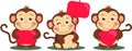 Three funny monkeys holding a red sign boards and heart Royalty Free Stock Photo
