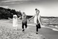 Three funny smiling laughing Caucasian children kids friends playing running on ocean sea beach Royalty Free Stock Photo