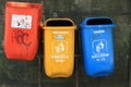 Three garbage recycle bin outdoor rubbish trash can color orange yellow blue