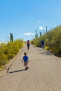 Three Generatiions Hike Up the Paved Path of a Desert Mountain W