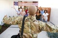 Three generation African American family welcoming millennial soldier returning home,back view, focus on foreground
