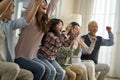 Three generation asian family watching soccer game telecast on TV Royalty Free Stock Photo