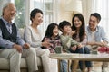 Three generation asian family watching tv together at home Royalty Free Stock Photo