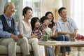 Three generation asian family watching tv together at home Royalty Free Stock Photo