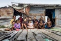 Three generation of Bajau tribe sit outside their wooden hut.