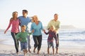 Three Generation Family On Holiday Running Along Beach Royalty Free Stock Photo