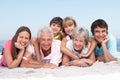 Three Generation Family Relaxing On Beach