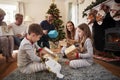 Three Generation Family Wearing Pajamas In Lounge At Home Opening Gifts On Christmas Day Royalty Free Stock Photo