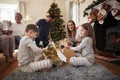 Three Generation Family Wearing Pajamas In Lounge At Home Opening Gifts On Christmas Day Royalty Free Stock Photo