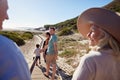 Three generation white family walking on a beach, grandparents in the foreground, over shoulder view Royalty Free Stock Photo