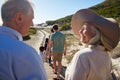 Three generation white family walking on a beach, grandparents in the foreground, over shoulder view Royalty Free Stock Photo