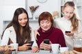 Three generations of family absorbedly looking at phones Royalty Free Stock Photo