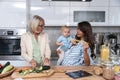 Three Generations Family. Grandma, mother and baby record a cooking vlog or podcast while chopping vegetables for a healthy Royalty Free Stock Photo