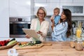 Three Generations Family. Grandma, mother and baby record a cooking vlog or podcast while chopping vegetables for a healthy Royalty Free Stock Photo