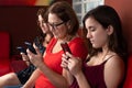 Three generations of hispanic women looking at their smartphones