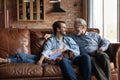 Three generations of men relax on sofa at home Royalty Free Stock Photo