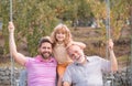Three generations of men together, portrait of smiling son, father and grandfather swinging on the swing, having fun in Royalty Free Stock Photo