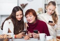 Three generations of family absorbedly looking at phones Royalty Free Stock Photo