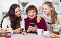 Three generations of family absorbedly looking at phones Royalty Free Stock Photo