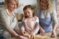 Three generations of women preparing Easter cookies Royalty Free Stock Photo