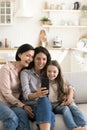 Three generations of women rest on couch with cellphone Royalty Free Stock Photo
