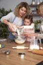 Three generations of women sifting flour for homemade cookies