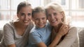 Three generations of women sitting on couch looking at camera Royalty Free Stock Photo