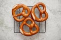 Three german fresh baked pretzel buns placed on steel grill frame