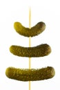 Three gherkins on a skewer, on a white background Royalty Free Stock Photo