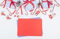 Three gift boxes in a blue stripe with red ribbons, fir branches and a blank sheet of paper lie on a white Royalty Free Stock Photo